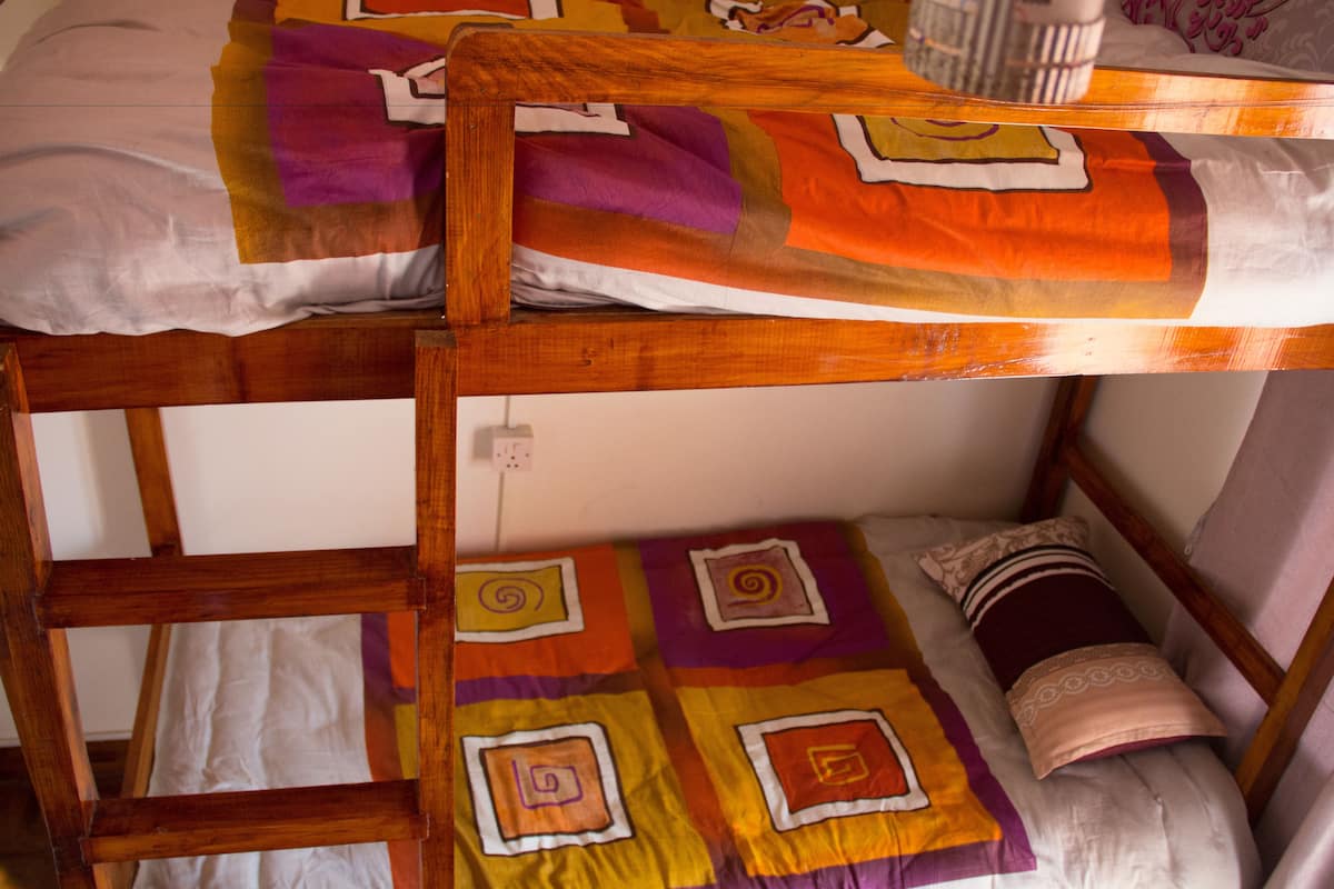 A bunk bed with a colorful quilt and a pillow.