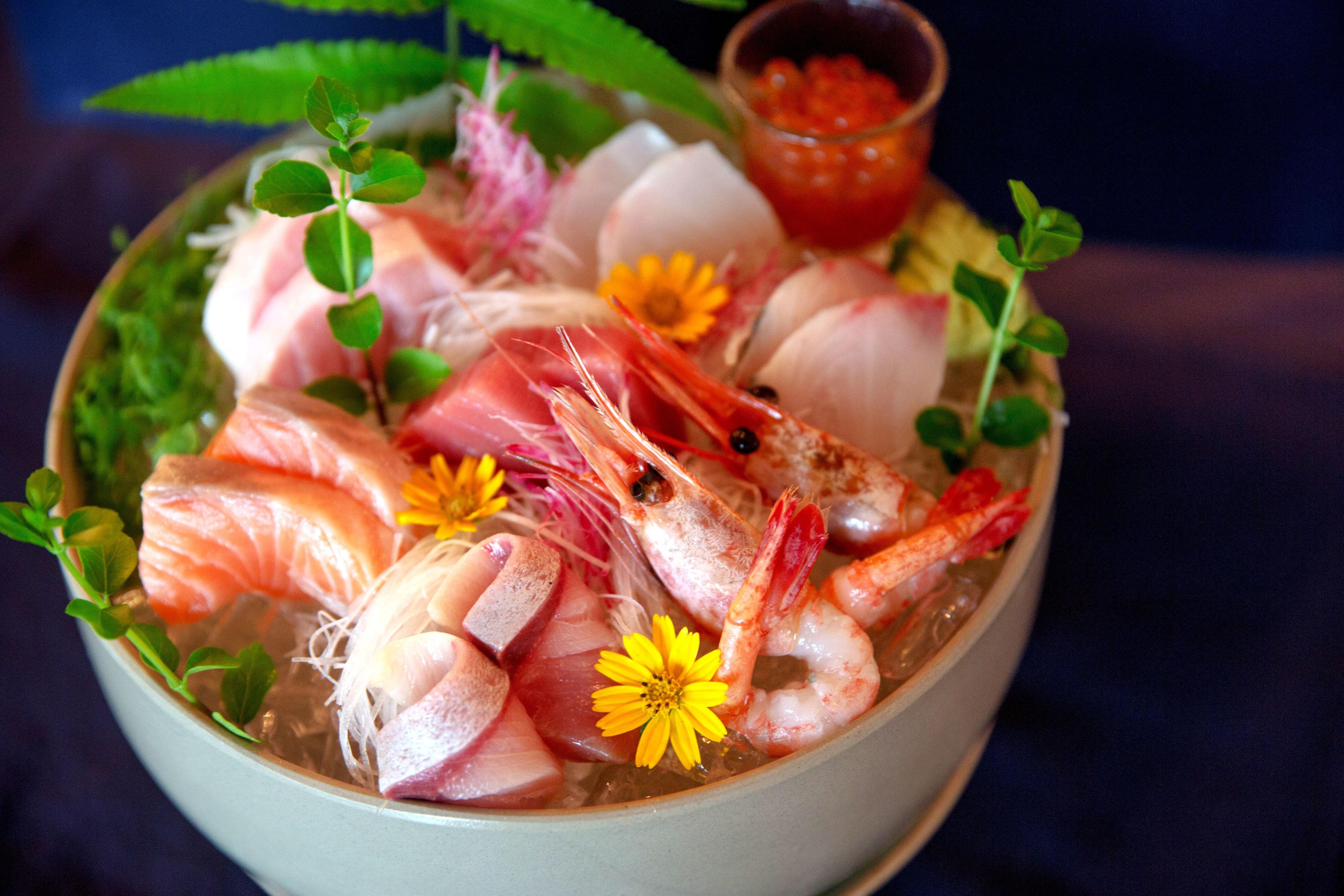 Un tazón de sopa de mariscos con camarones, pescado y verduras.