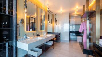 A modern bathroom with a large mirror, two sinks, and a vanity area.