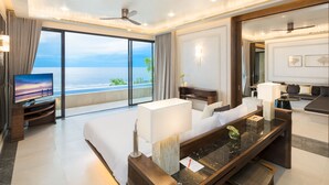 Quarto de hotel moderno com varanda grande, televisão de tela plana, sofá, escrivaninha e área de refeições.