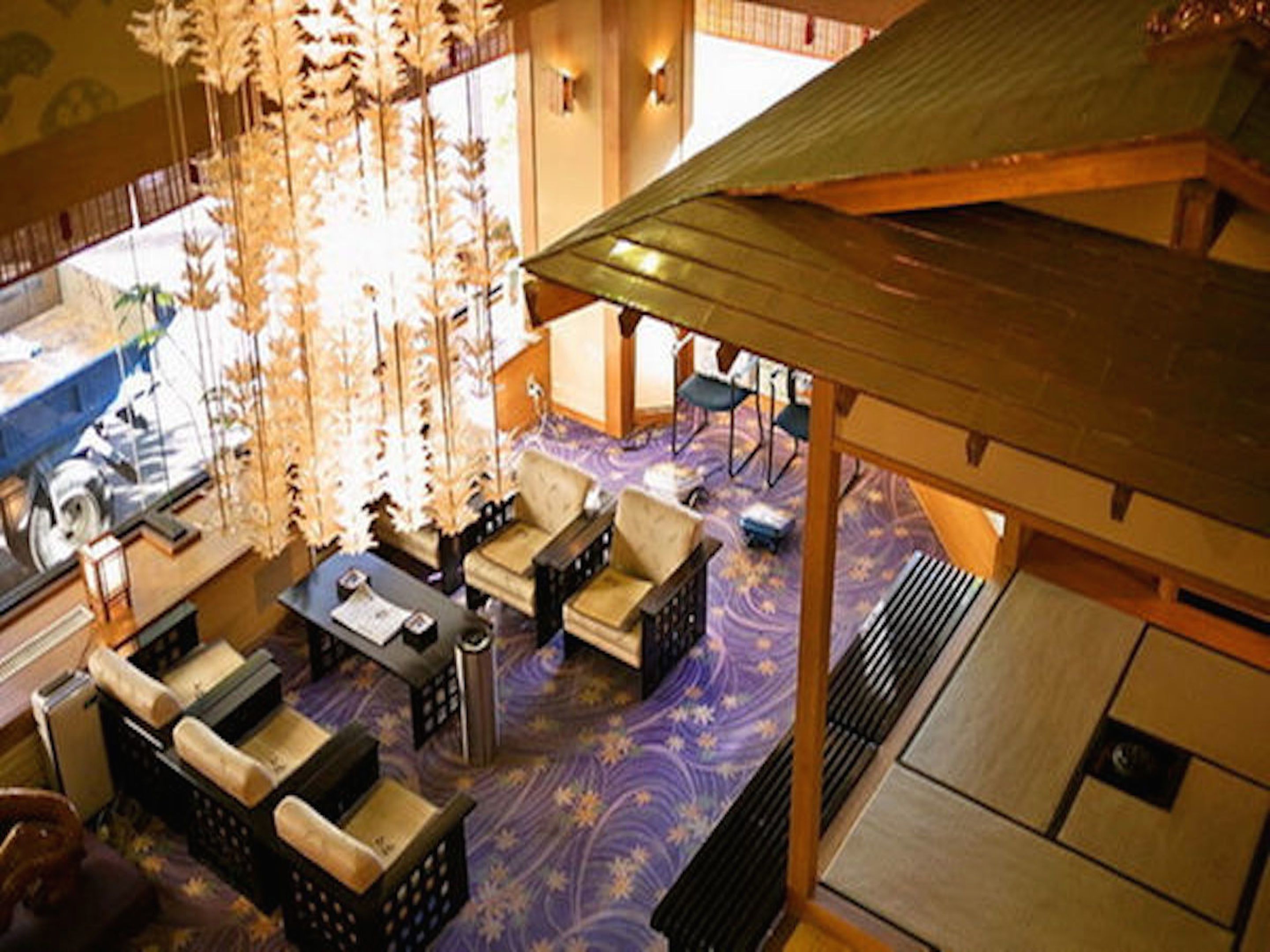 A spacious living area with a purple patterned carpet, multiple sofas, and a coffee table.