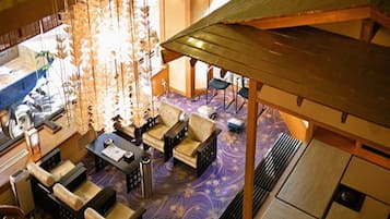 A spacious living area with a purple patterned carpet, multiple sofas, and a coffee table.