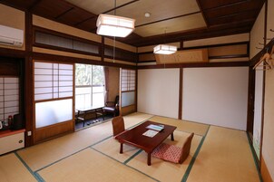 Una tradizionale stanza giapponese con pavimento in tatami, un tavolo di legno e porte scorrevoli shoji.