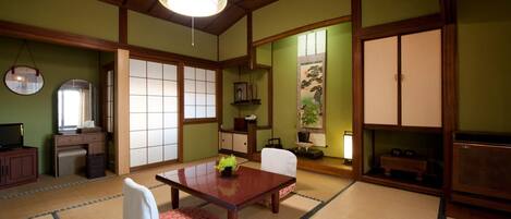 Una habitación japonesa tradicional con suelo de tatami, una mesa de madera baja y una puerta corredera.