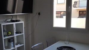 Eine moderne Küche mit weißer Arbeitsplatte, einem eingebauten Herd und einem großen Fenster mit Blick nach draußen.