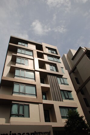 A multi-story building with a modern architectural design, featuring a series of balconies and large windows. - Portico Residence (Bangkok)