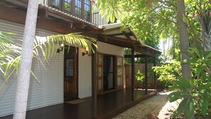 A two-story house with a wooden deck and a covered porch. - Beach House on Fox (Cable Beach)
