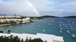 A coastal view with a rainbow, boats, and a white building complex. -   Spacious 3 Bed 3 Full Baths With Spectacular Views of St John- Ocean Front!
 (Saint Thomas)