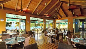 A spacious indoor dining area with high ceilings and large windows. Tables are set with chairs, and the floor has a patterned tile design. -   Spacious 3 Bed 3 Full Baths With Spectacular Views of St John- Ocean Front!
 (Saint Thomas)