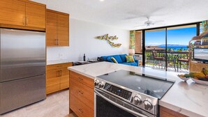 Eine moderne Küche mit Holzausstattung, einem Edelstahlkühlschrank und einer großen Kochinsel.