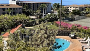 Ein Hotel mit Schwimmbad, Palmen und Meerblick.