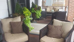A covered outdoor seating area with wicker furniture and potted plants. - Victorian Home - Golfers Welcome (Ventnor)