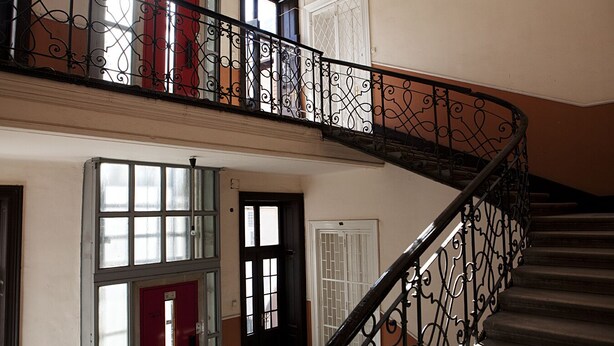 A staircase with ornate black railings leading to an upper floor.