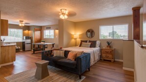 A modern apartment with a kitchen, dining area, and a bedroom with a large bed and bedside tables. - Gorgeous Casita In The Heart Of Historic Old Town  (Albuquerque)