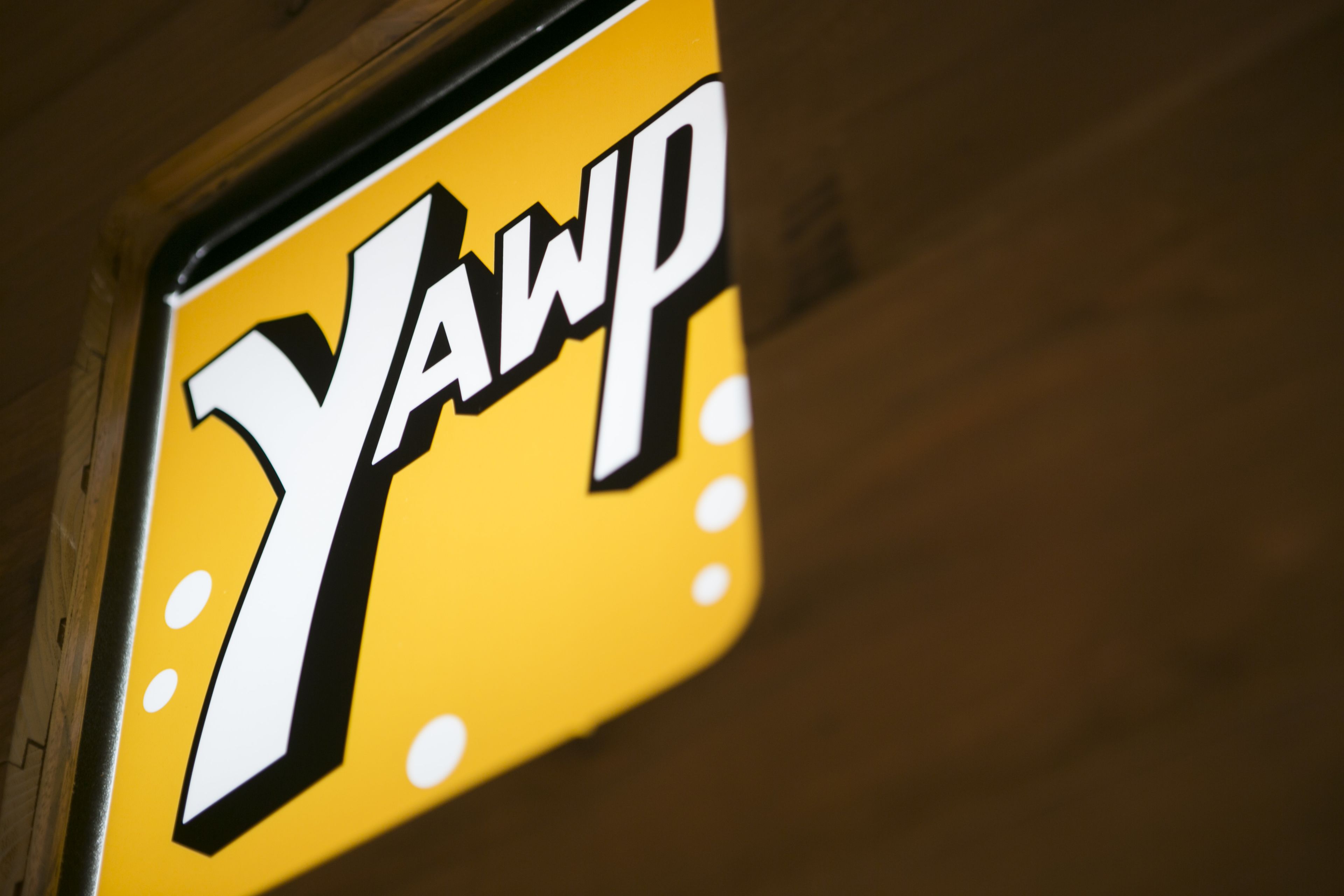 Un segnale giallo con la scritta 'YAWP' in caratteri neri e marcati.