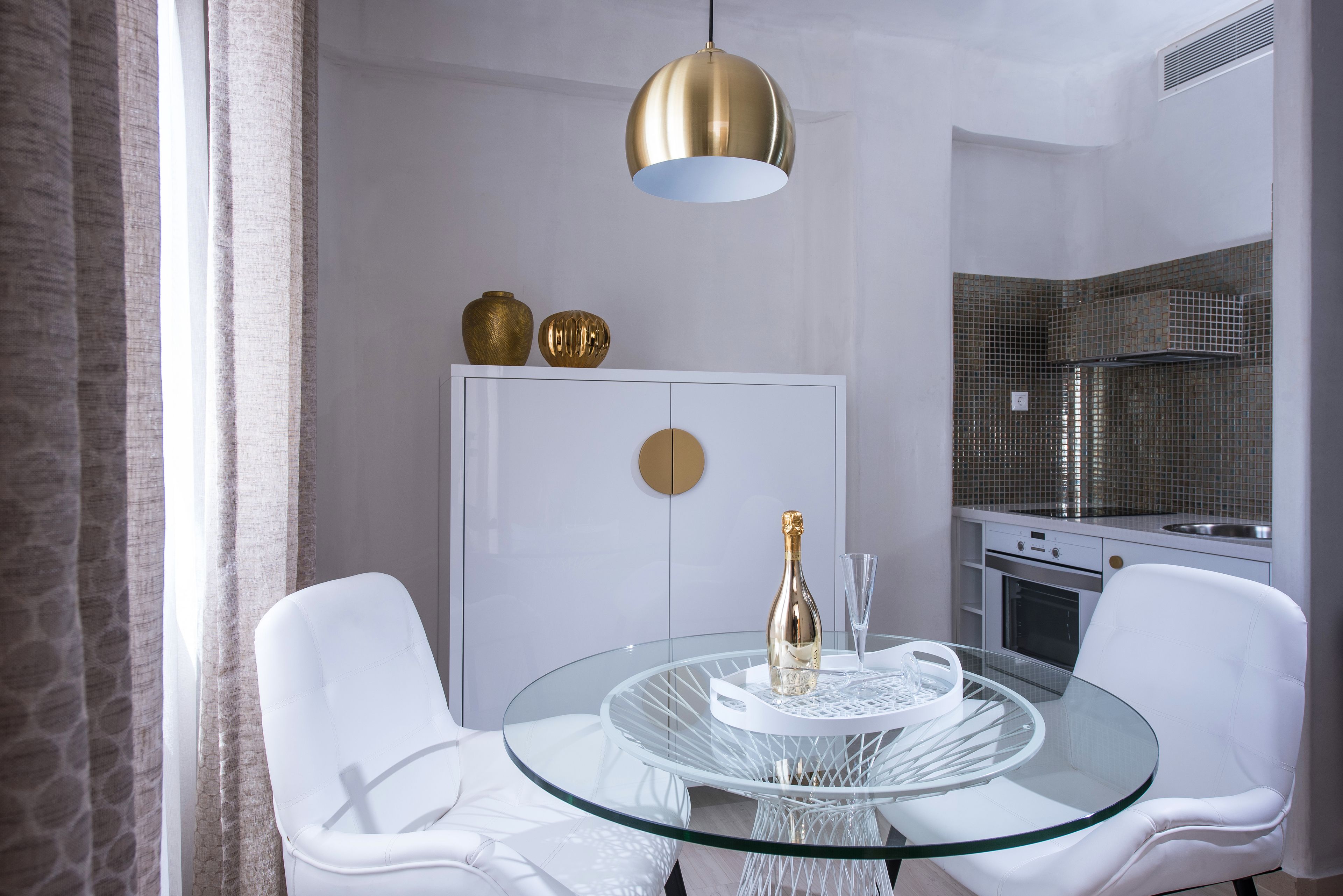 A modern kitchen with white cabinets, a white refrigerator, and a built-in oven.