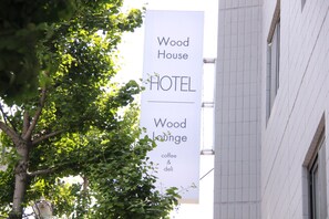 A sign for Wood House Hotel and Wood Lounge, indicating the presence of a coffee and deli. - Wood House Hotel (Busan)