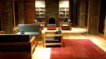 A cozy room with a fireplace, wooden furniture, and bookshelves.