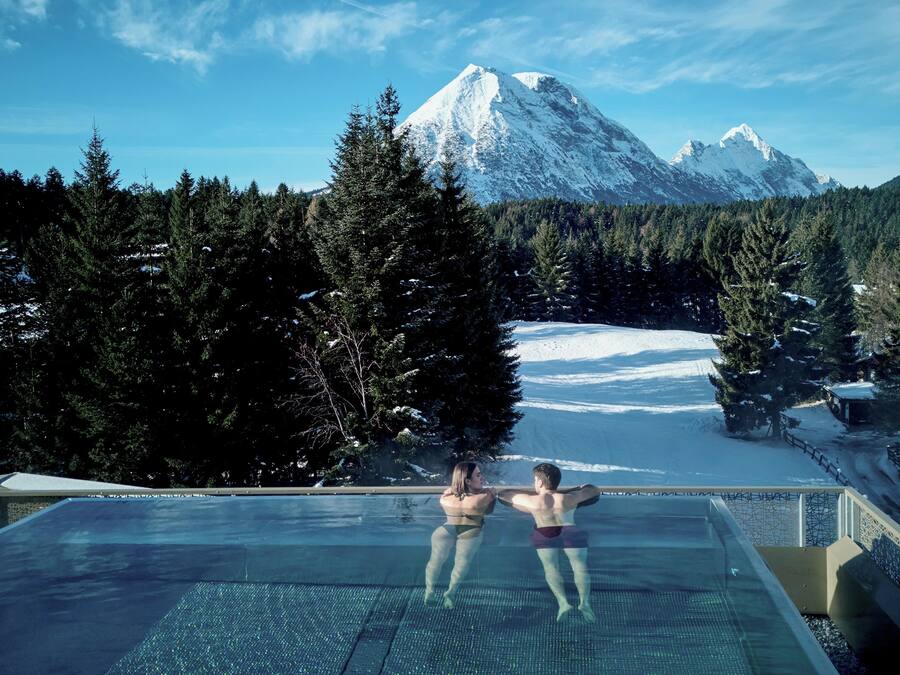 Una piscina cubierta, una piscina al aire libre, tumbonas