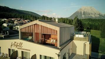 A modern building with a wooden exterior and a glass balcony.