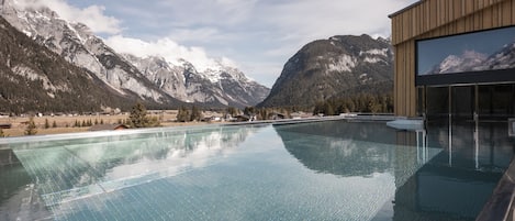 Una piscina cubierta, una piscina al aire libre, tumbonas