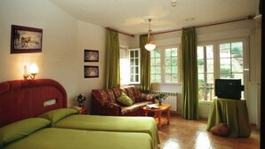 A room with a bed, a sofa, a television on a table, and a window with curtains. - Apartamentos Turisticos Cumbres Verdes (La Zubia)