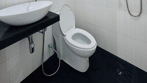 A bathroom with a white sink, a toilet, a handheld showerhead, and a mirror. - K.L.Apartment (Rawai)