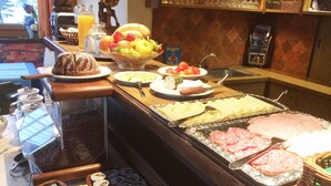 A buffet with various food items including fruits, vegetables, and meats. - Pension Roetelstein (Ramsau am Dachstein)