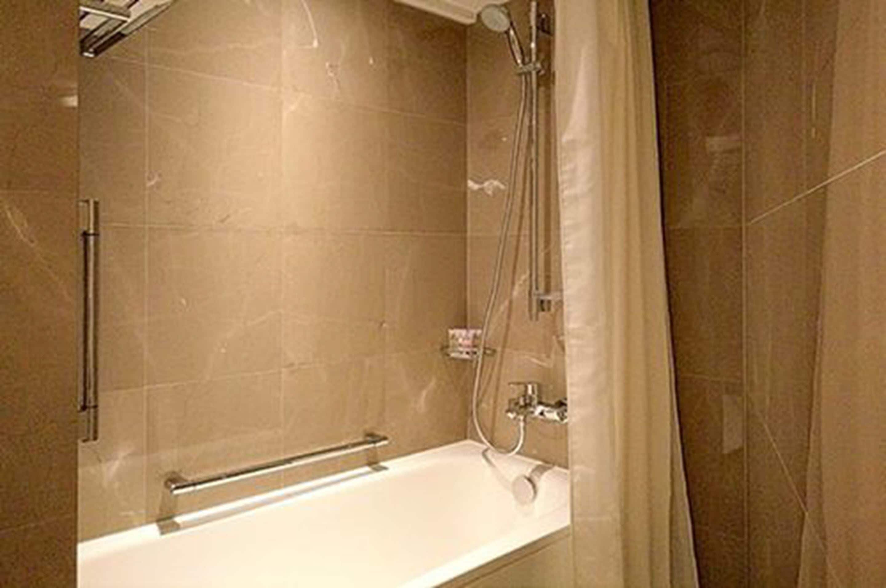 combined shower/bathtub, deep-soaking bathtub, hair dryer, slippers