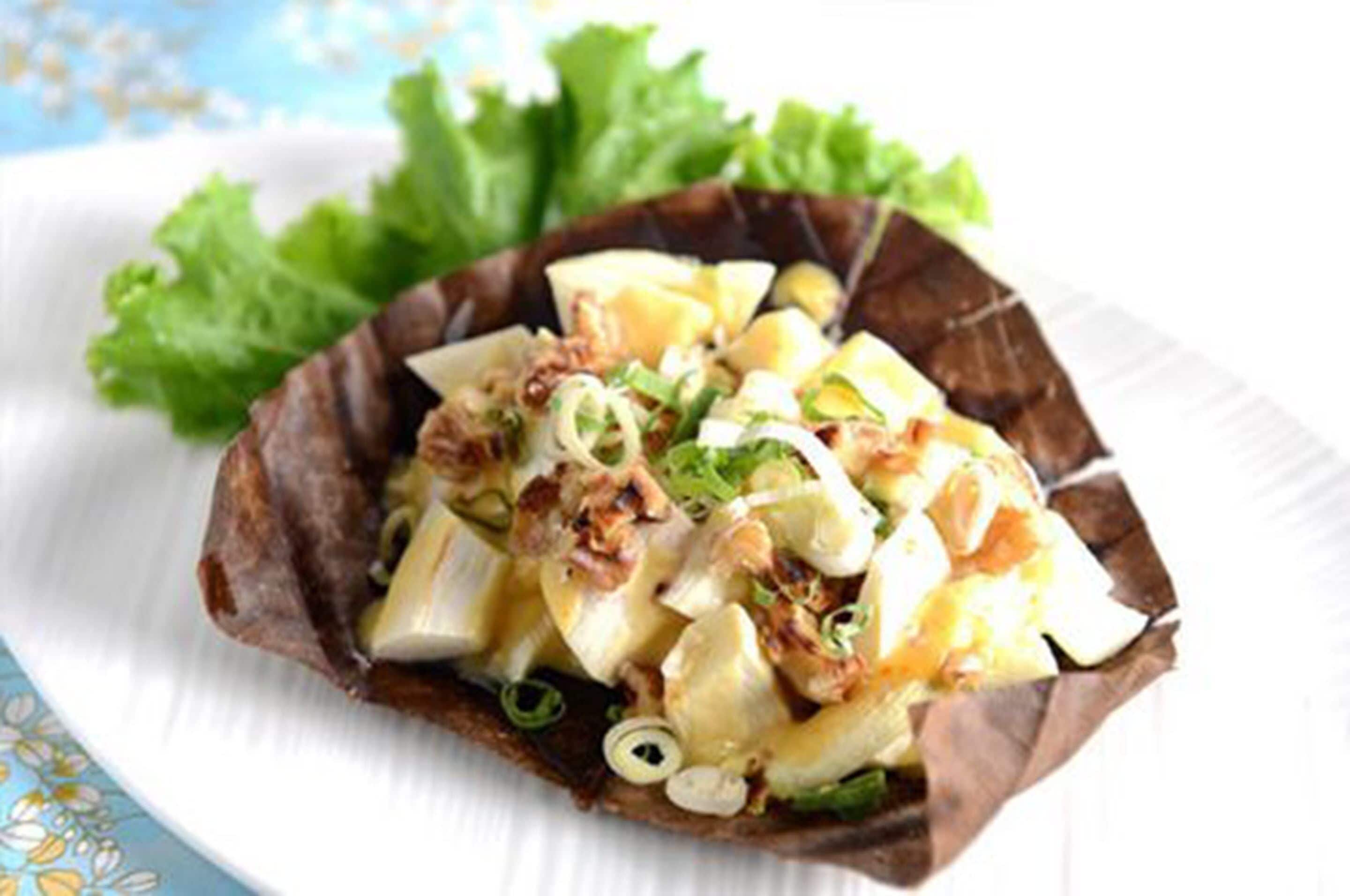 A dish in a shell-shaped bowl with a white plate underneath.