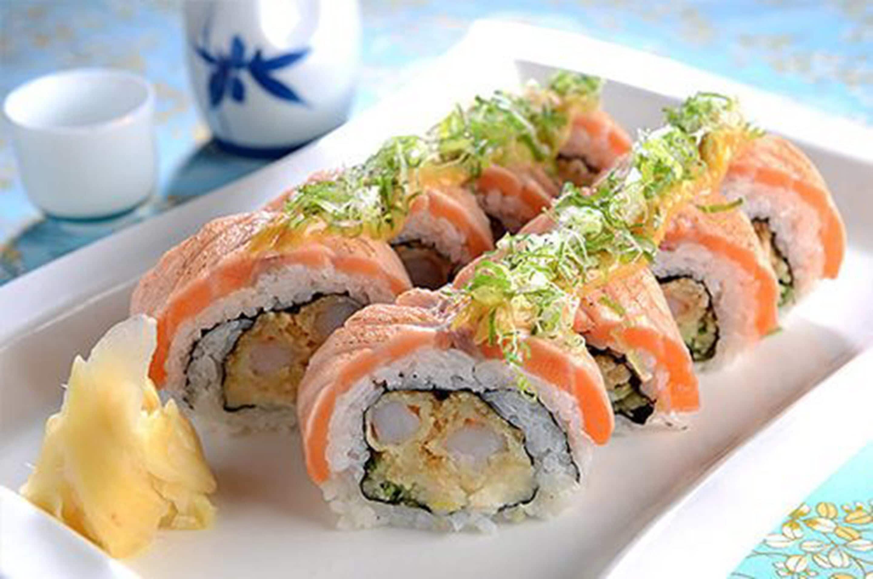 A plate of sushi rolls with a side of wasabi.