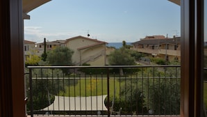 Un balcón con vista a una zona residencial y al mar.