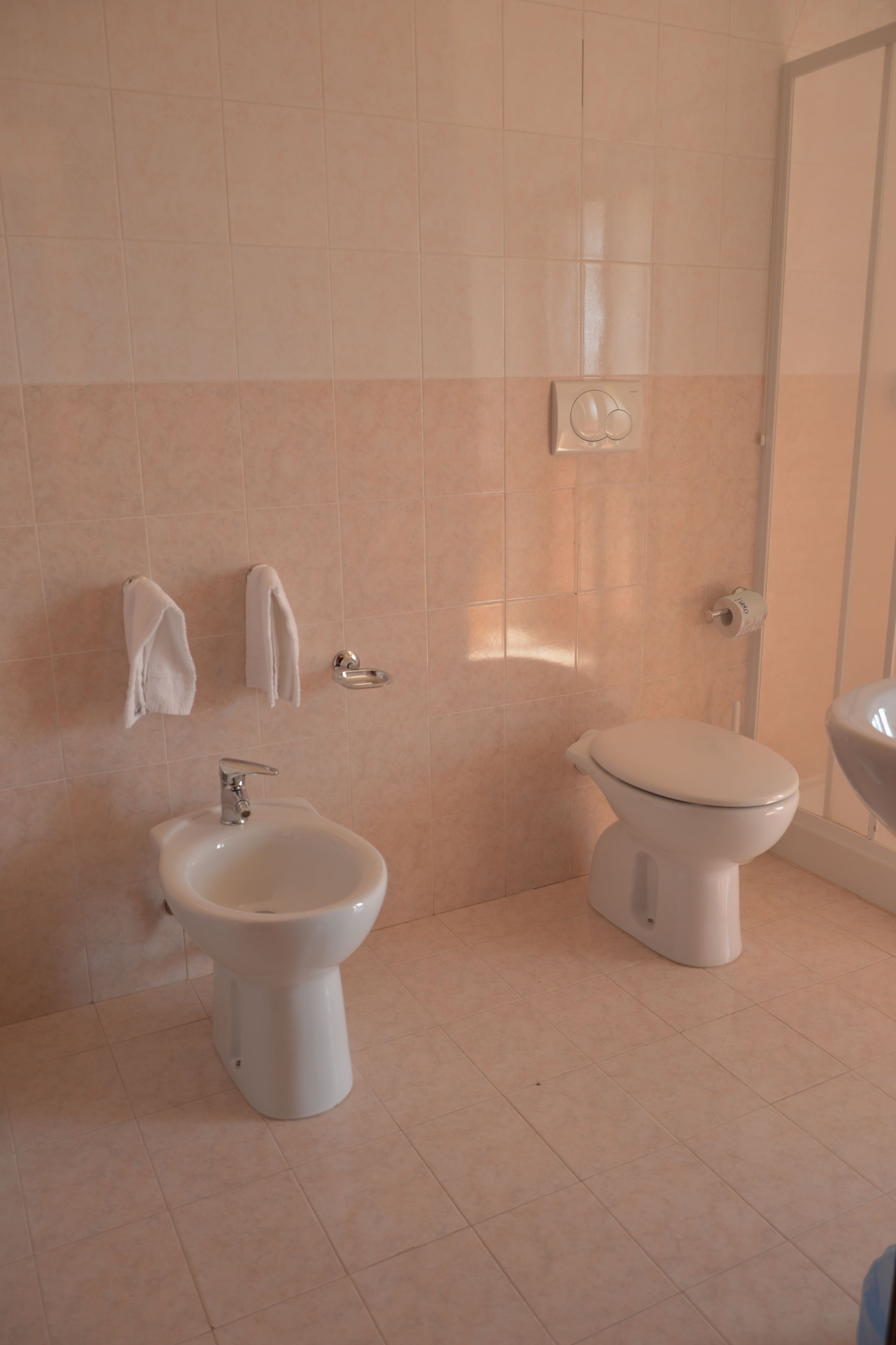 Un bagno con bidet, WC e lavabo.