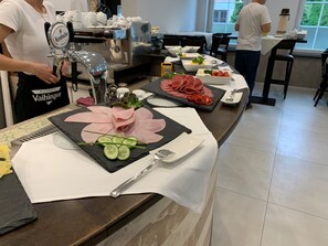 Un bufé de desayuno con diferentes alimentos y una máquina de café.