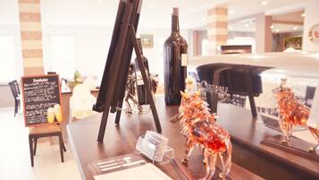 A restaurant interior with a wooden table, a wine bottle, and a lobster sculpture.