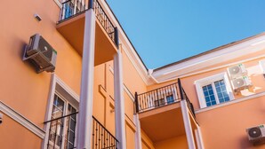 A multi-story building with balconies, air conditioning units, and a clear blue sky. - Potemkinn Hotel (Odesa)