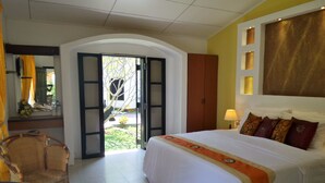 Una camera d'albergo con un letto, una sedia, una scrivania e vista sull'esterno.