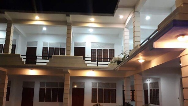 A multi-story building with a symmetrical facade, large windows, and a central entrance. - Hotel senora kataragama (Kataragama)