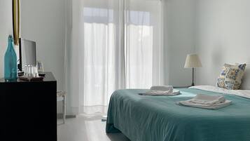 A bedroom with a bed, a desk, a lamp, and an air conditioning unit.