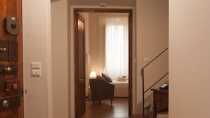 A hallway with wooden flooring, a door on the left, and a staircase on the right. - La Porta del Paradiso (Florence)