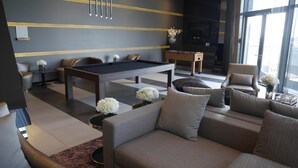 A modern living room with a pool table, sofas, and a foosball table. - Sky Home at Bangkok-Bangna (Bangkok)
