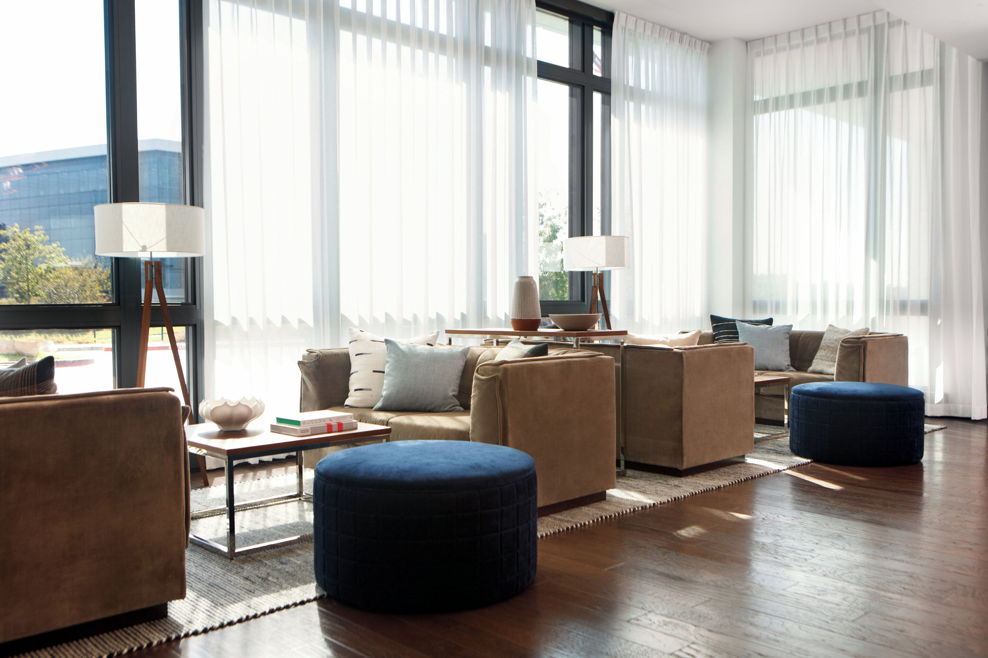 Un salon moderne comprenant un canapé, des poufs, une table basse et un téléviseur.
