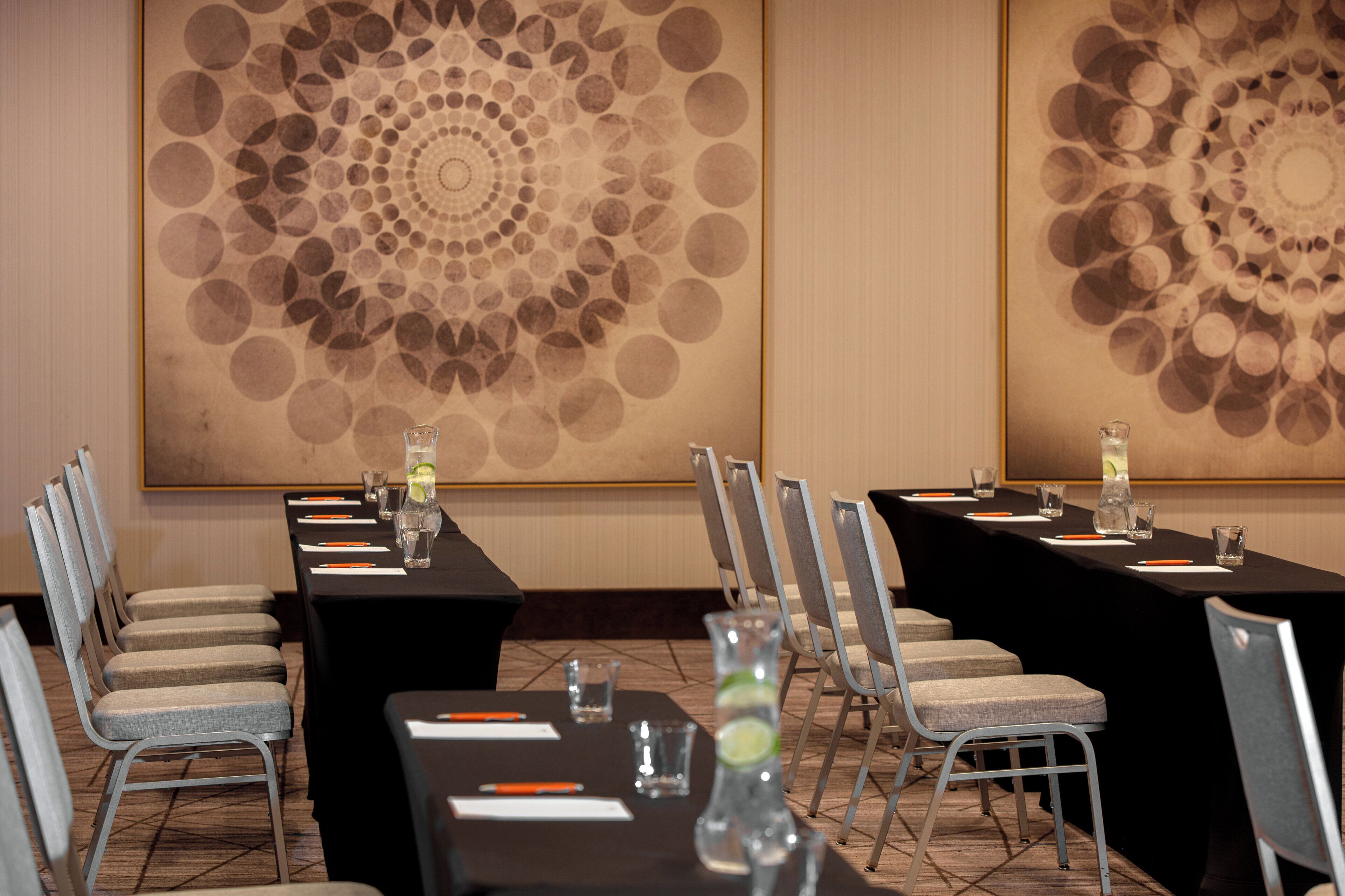A conference room with a long table, chairs, and a decorative wall.