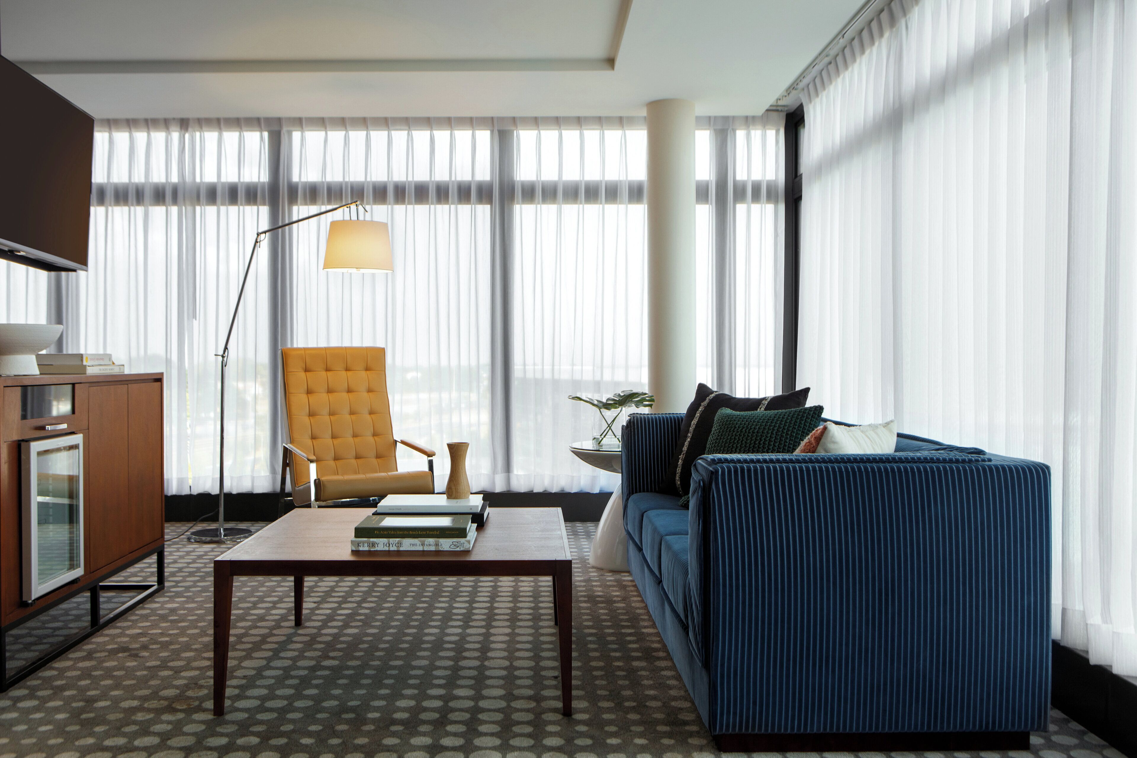 A modern living room with a sofa, armchair, coffee table, and a floor lamp.