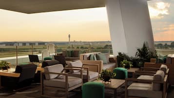 A lounge area with seating and a view of the airport.