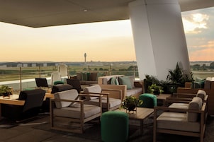 A lounge area with seating and a view of the airport.