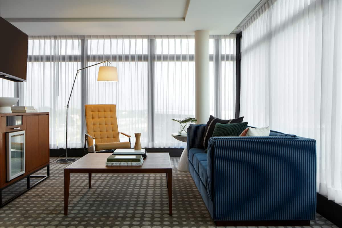 A modern living room with a blue sofa, a wooden coffee table, and a floor lamp.