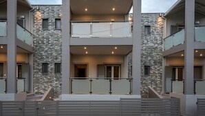 A multi-level building with a stone facade, balconies, and a gated entrance.