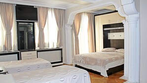 Une chambre d’hôtel avec deux lits, une télévision, un bureau et une armoire.