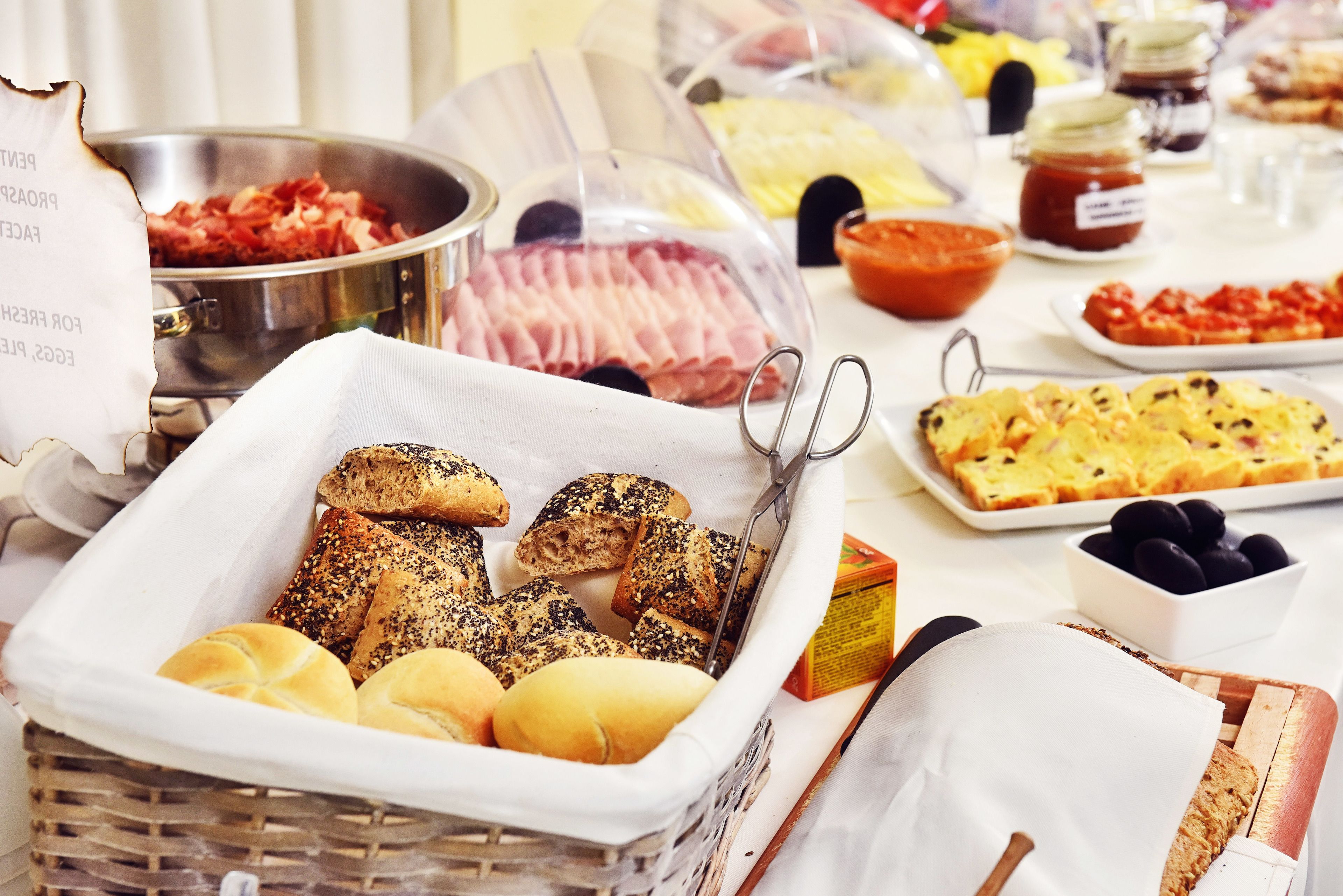 A buffet table with various food items including bread, cheese, and meats.
